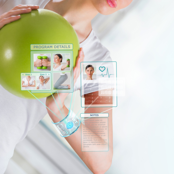 Woman doing exercise with ball wearing smart wearable device wit